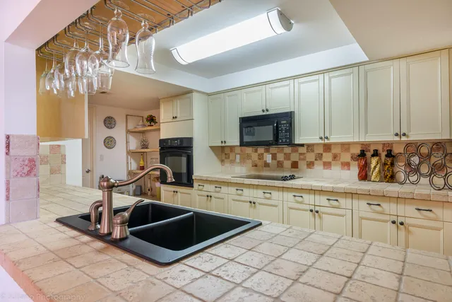 a kitchen with granite countertop a sink and a stove top oven