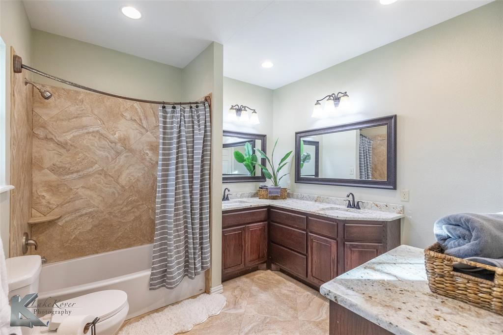 1198 Iberis Road South, Unit B Tuscola, TX 79562 - Photo 20 of 40 a bathroom with a double vanity sink toilet mirror and bathtub