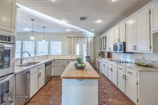 a kitchen with sink stove top oven and refrigerator