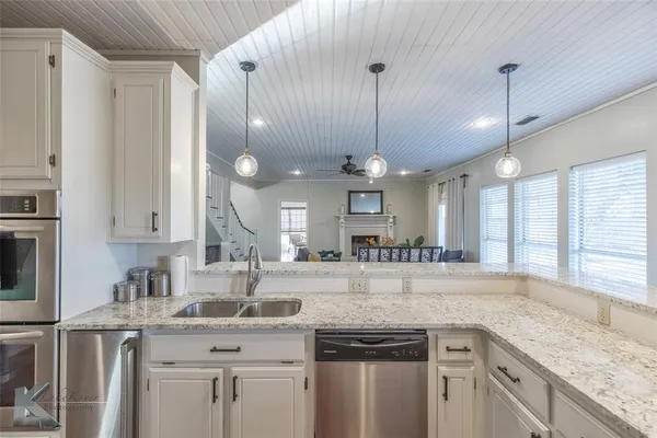 a kitchen with stainless steel appliances granite countertop a sink a stove and a wooden floors