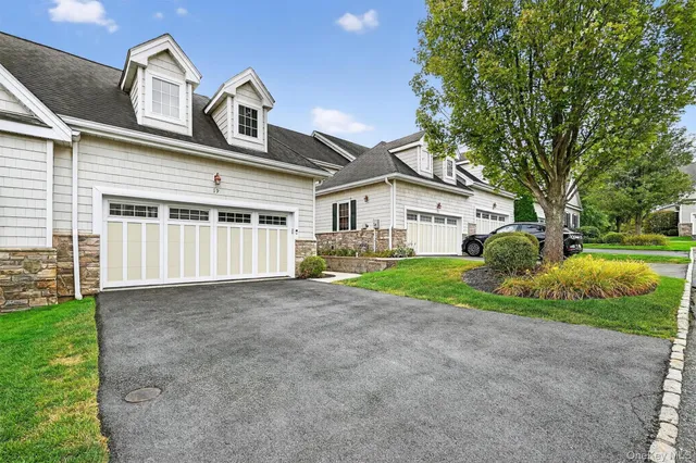 a view of a house with a yard and large tree