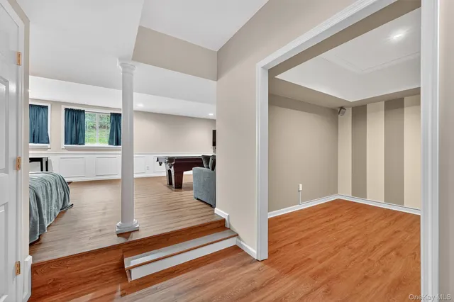 a bedroom with a bed and a large mirror on the dresser