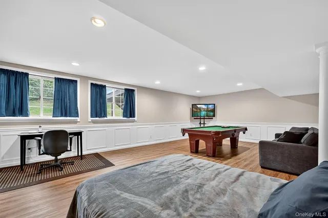 a view of a livingroom with wooden floor and a flat screen tv