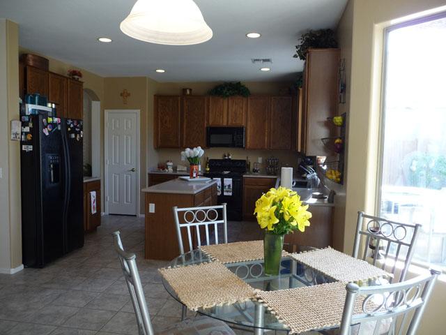 2416 West Carter Road Phoenix, AZ 85041 - Photo 9 of 32 a kitchen with stainless steel appliances granite countertop a dining table cabinets and a potted plant
