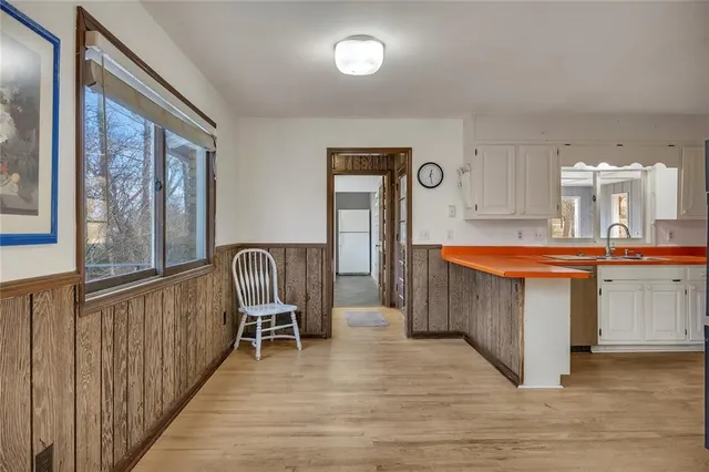 a view of a kitchen with a sink and dishwasher a refrigerator with wooden floor