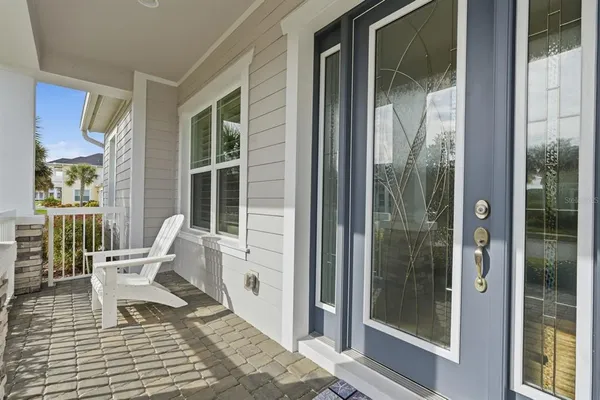 a balcony with chairs and glass door