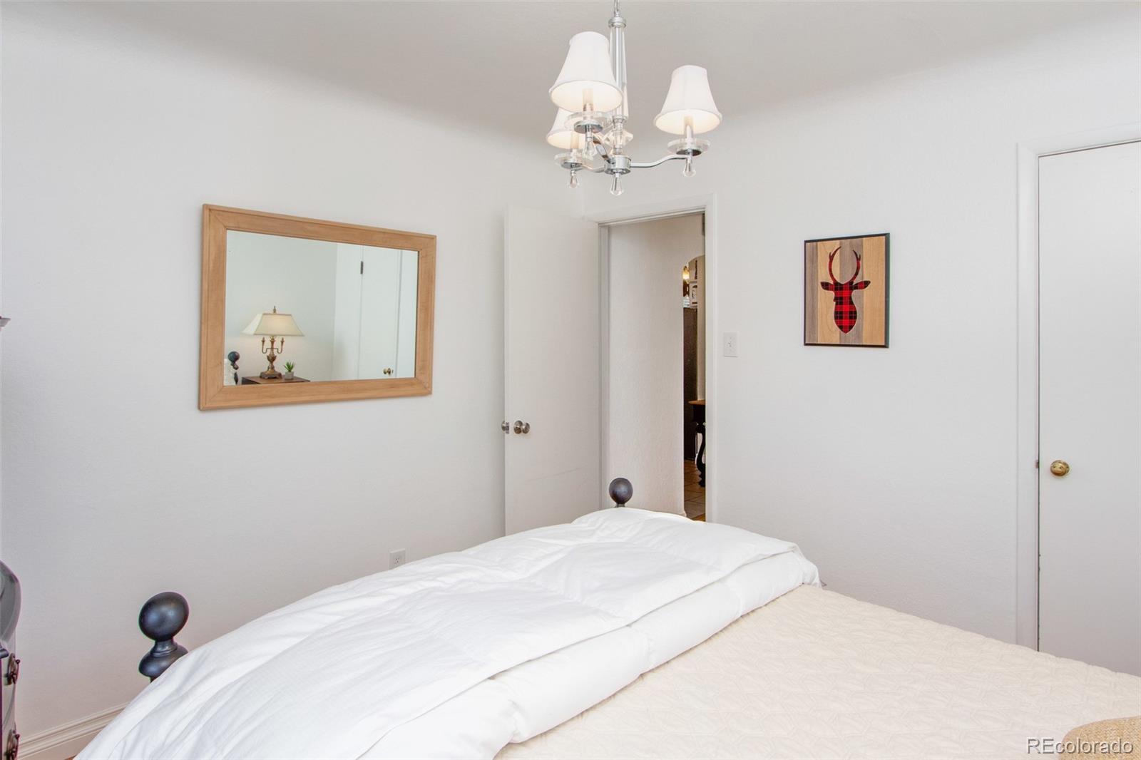 1635 Montview Road Greeley, CO 80631 - Photo 12 of 25 a bedroom with a large bed and a chandelier