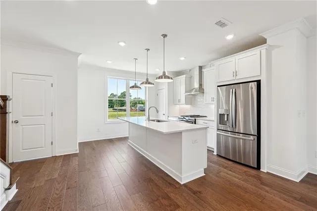 a kitchen with kitchen island white cabinets and stainless steel appliances