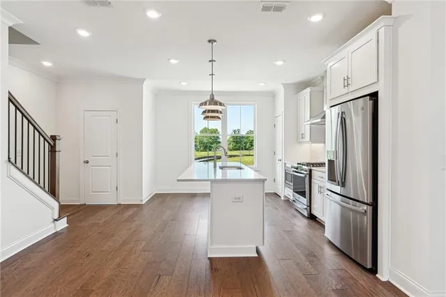 an empty room with wooden floor a ceiling fan and windows