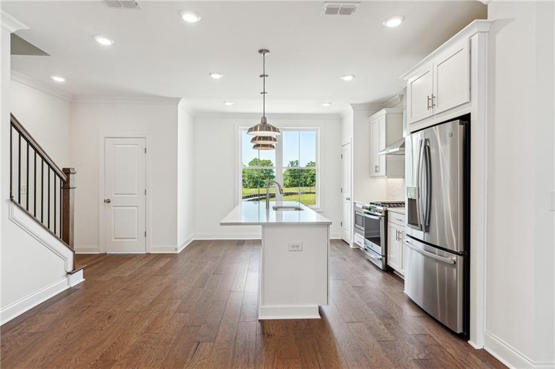 504 Healy Drive Cumming, GA 30040 - Photo 12 of 25 an empty room with wooden floor a ceiling fan and windows