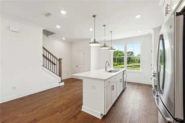 a kitchen with a sink a counter top space stainless steel appliances and a large window