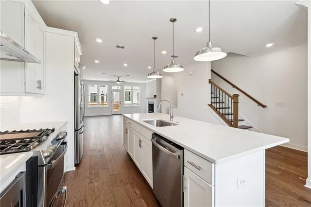 a kitchen with kitchen island a sink and stove