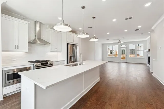 a large kitchen with lots of counter space wooden floor and appliances