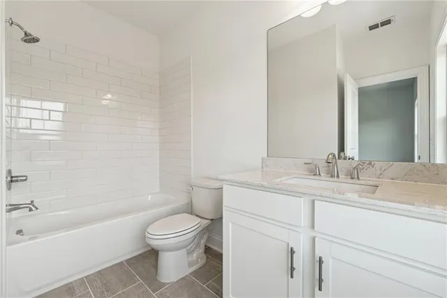 a bathroom with a granite countertop sink a toilet and a bathtub