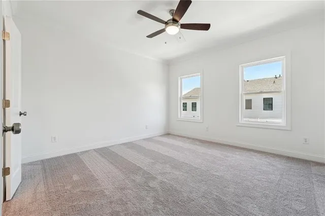 an empty room with windows and fan