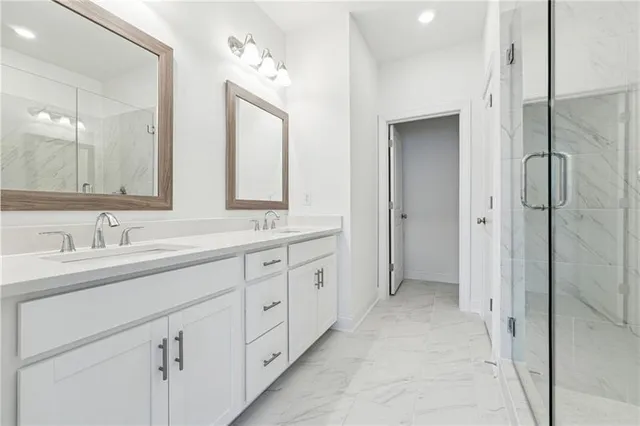 a spacious bathroom with double sink a mirror and a shower