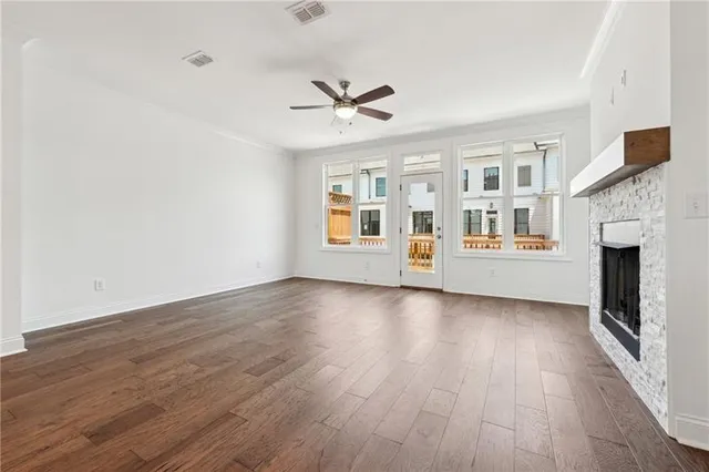 a view of a livingroom with wooden floor and a ceiling fan