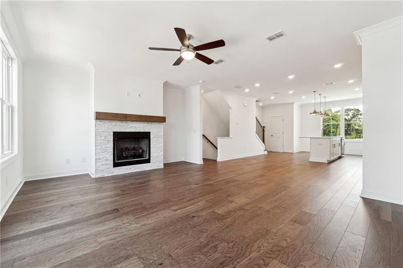 504 Healy Drive Cumming, GA 30040 - Photo 8 of 25 a view of a livingroom with a ceiling fan wooden floor and a kitchen