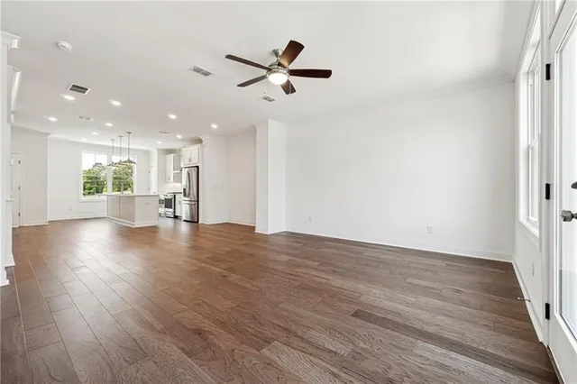 a view of empty room with wooden floor and window