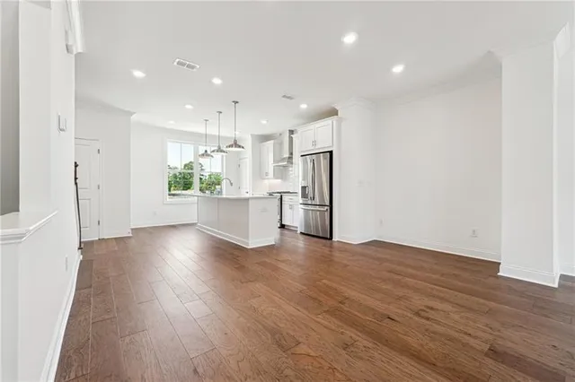 a view of a kitchen with wooden floor and a refrigerator
