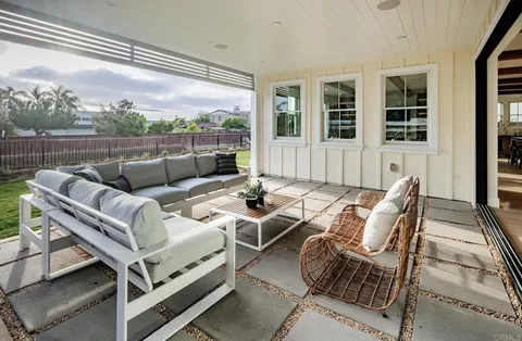 a view of a patio with couches chairs and wooden floor