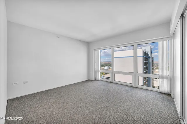 a view of an empty room with a fireplace and a large window