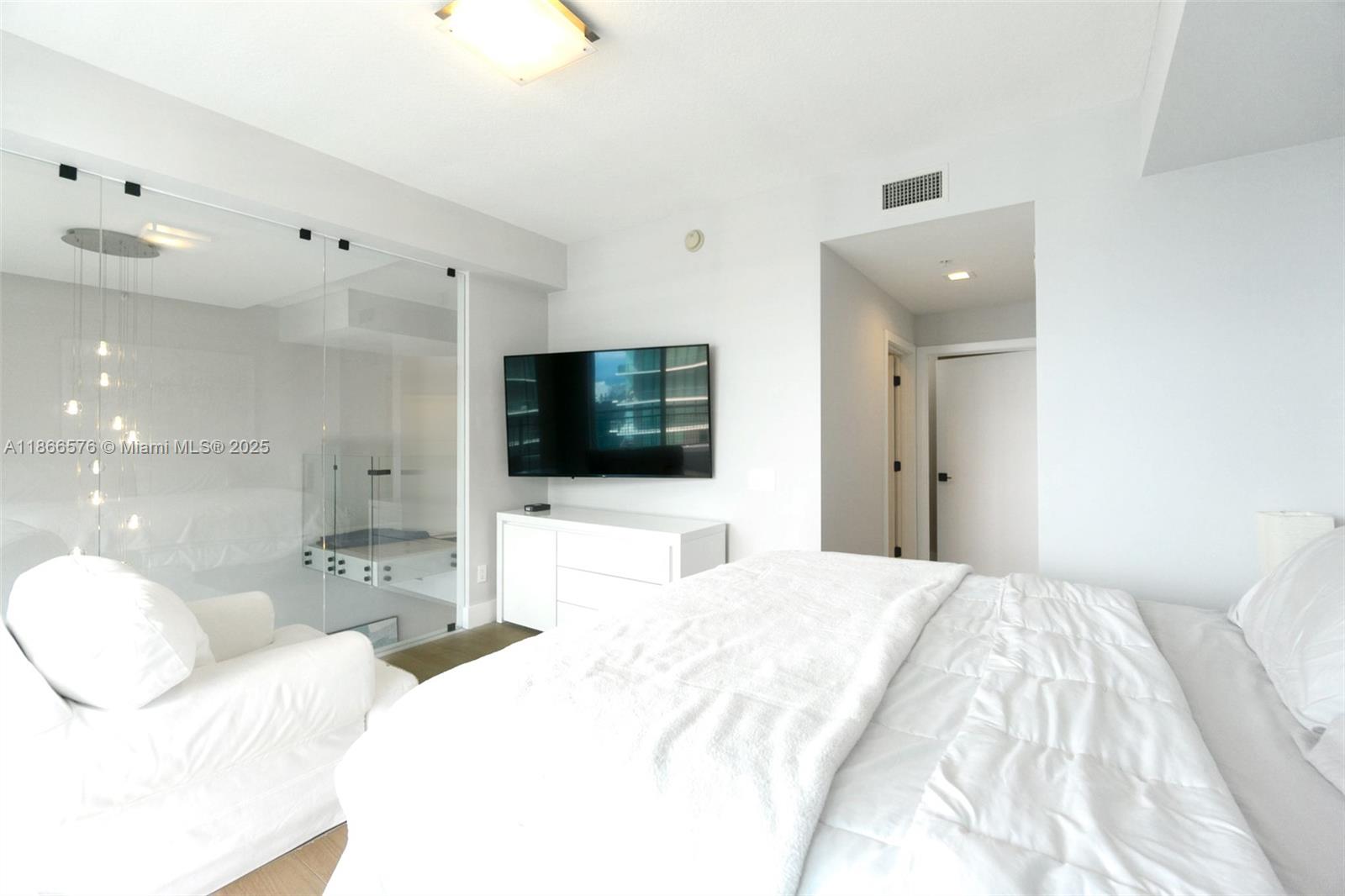 60 Southwest 13th Street, Unit 4802 Miami, FL 33130 - Photo 12 of 23 a bedroom with a bed and a flat screen tv