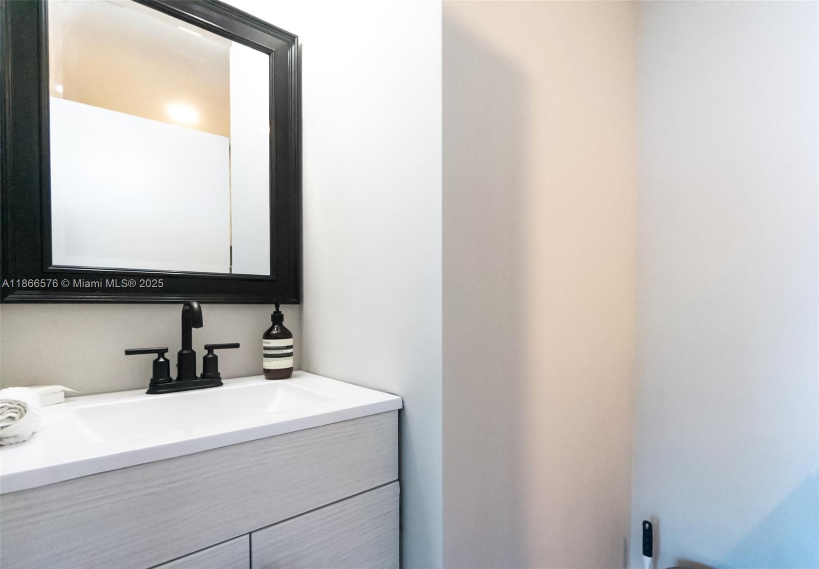 60 Southwest 13th Street, Unit 4802 Miami, FL 33130 - Photo 16 of 23 a bathroom with a sink and a mirror