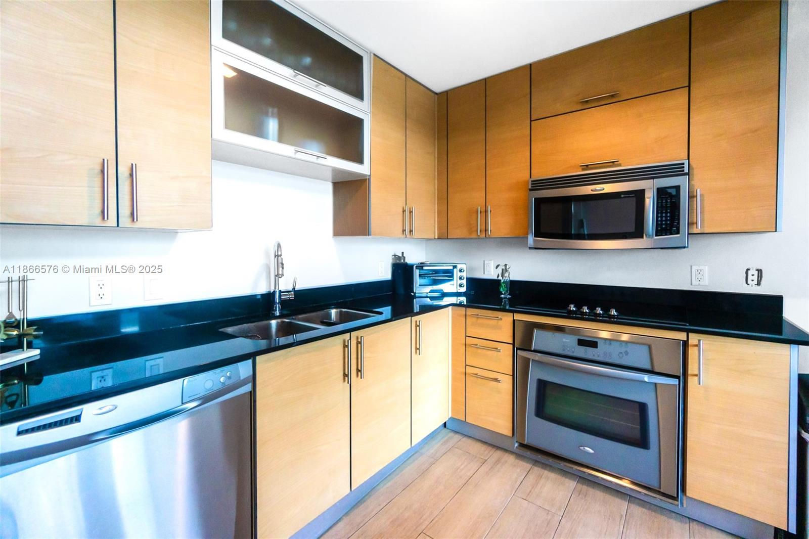 60 Southwest 13th Street, Unit 4802 Miami, FL 33130 - Photo 7 of 23 a kitchen with stainless steel appliances granite countertop a stove a sink and a microwave