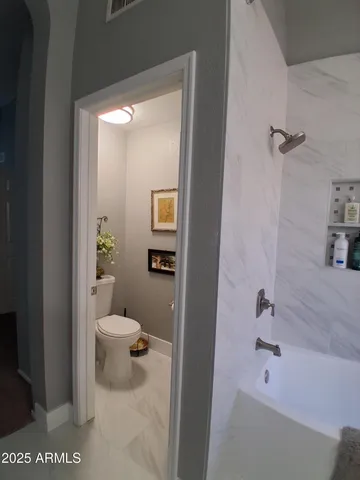 a bathroom with a granite countertop sink a toilet and shower