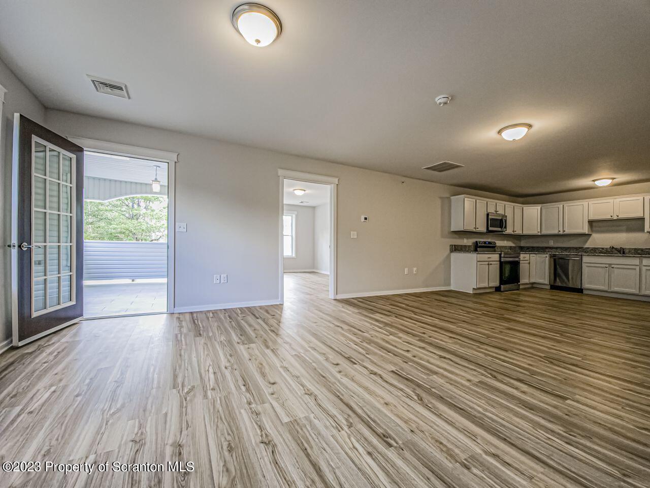 163 Bianca Way Old Forge, PA 18518 - Photo 4 of 24 an empty room with wooden floor and windows