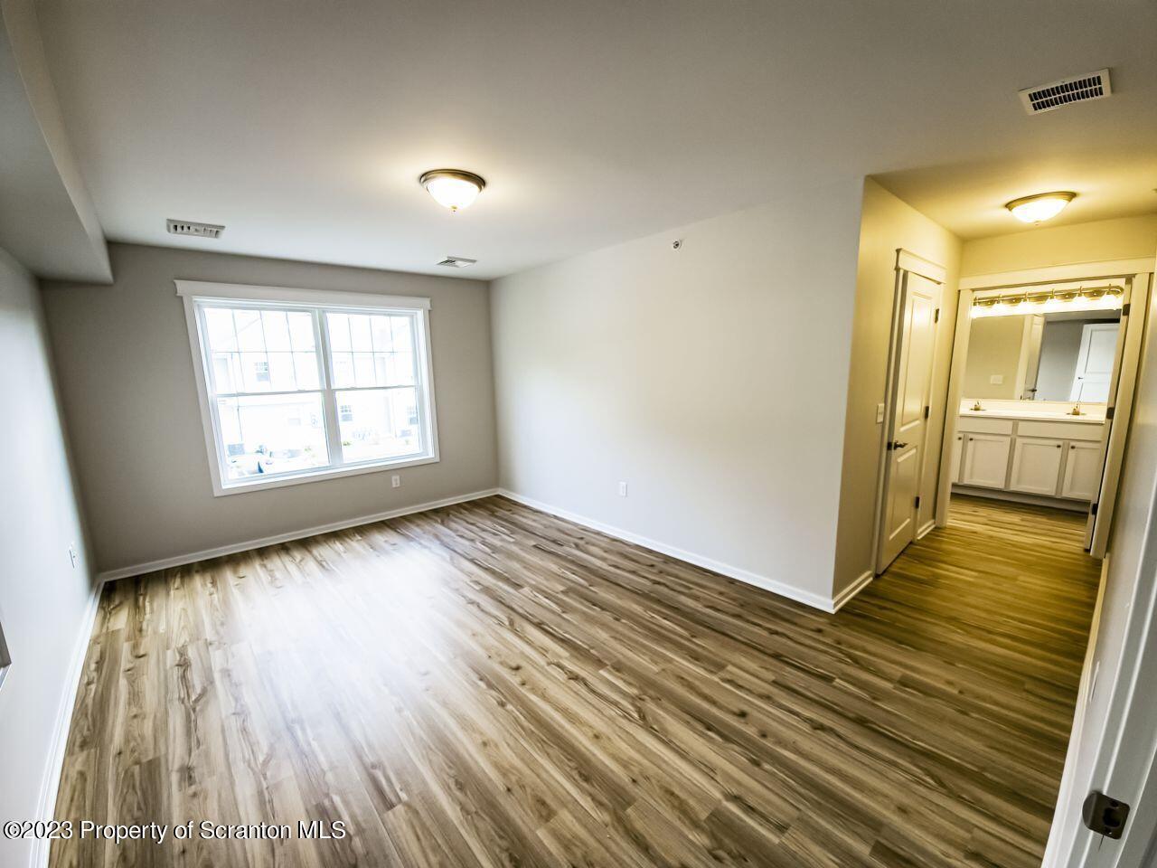 163 Bianca Way Old Forge, PA 18518 - Photo 7 of 24 an empty room with wooden floor and windows