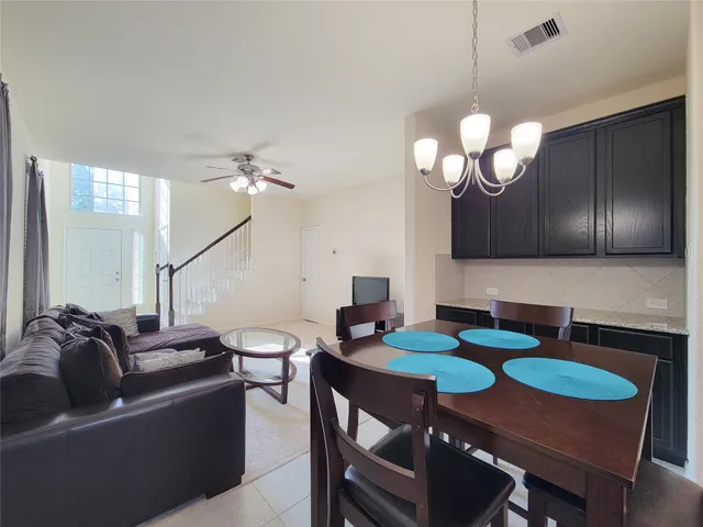 a living room with furniture a chandelier and a dining room