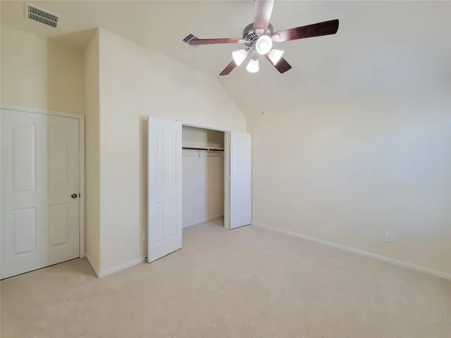 an empty room with a chandelier fan and a ceiling fan