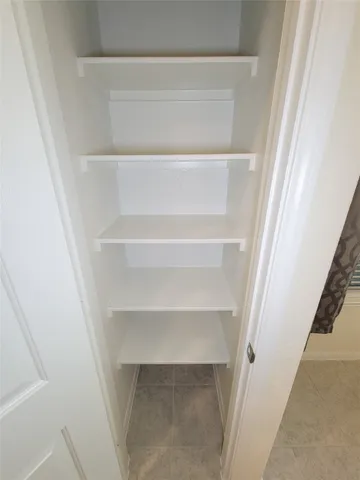 a view of walk in closet with empty racks