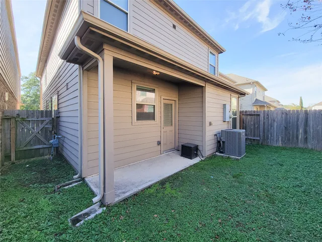 a view of backyard with barbeque grill potted plants and wooden fence