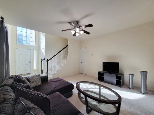 a living room with furniture a flat screen tv and a window