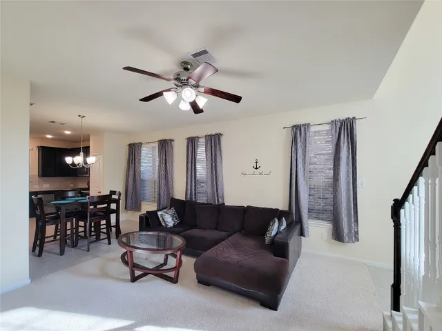 a living room with furniture ceiling fan and a rug