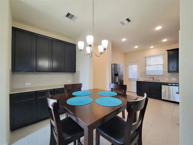 a kitchen with a dining table chairs and microwave