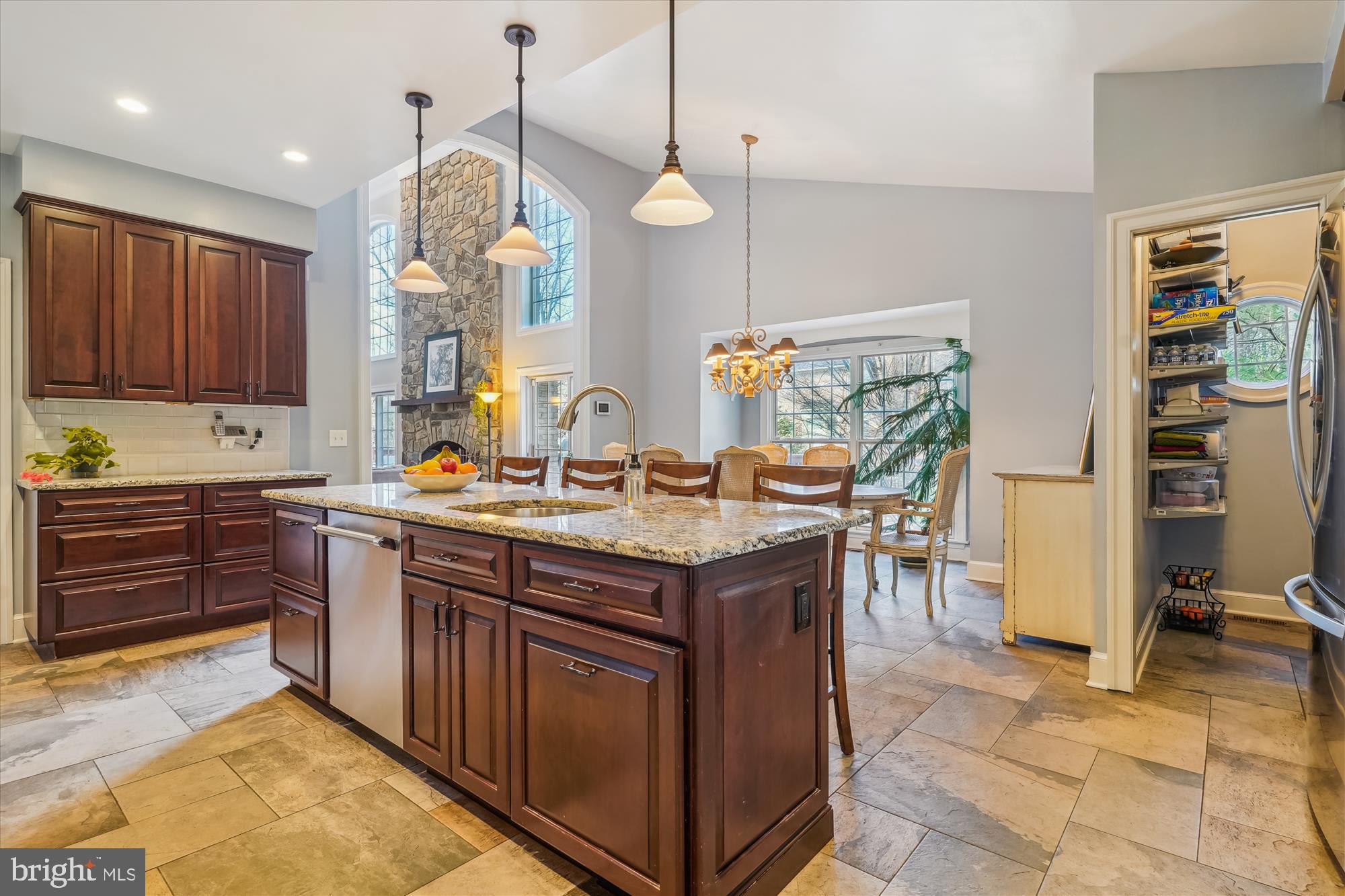6100 Solitaire Way McLean, VA 22101 - Photo 11 of 60 a kitchen with a stove kitchen island granite countertop a stove a sink a dining table and chairs with wooden floor