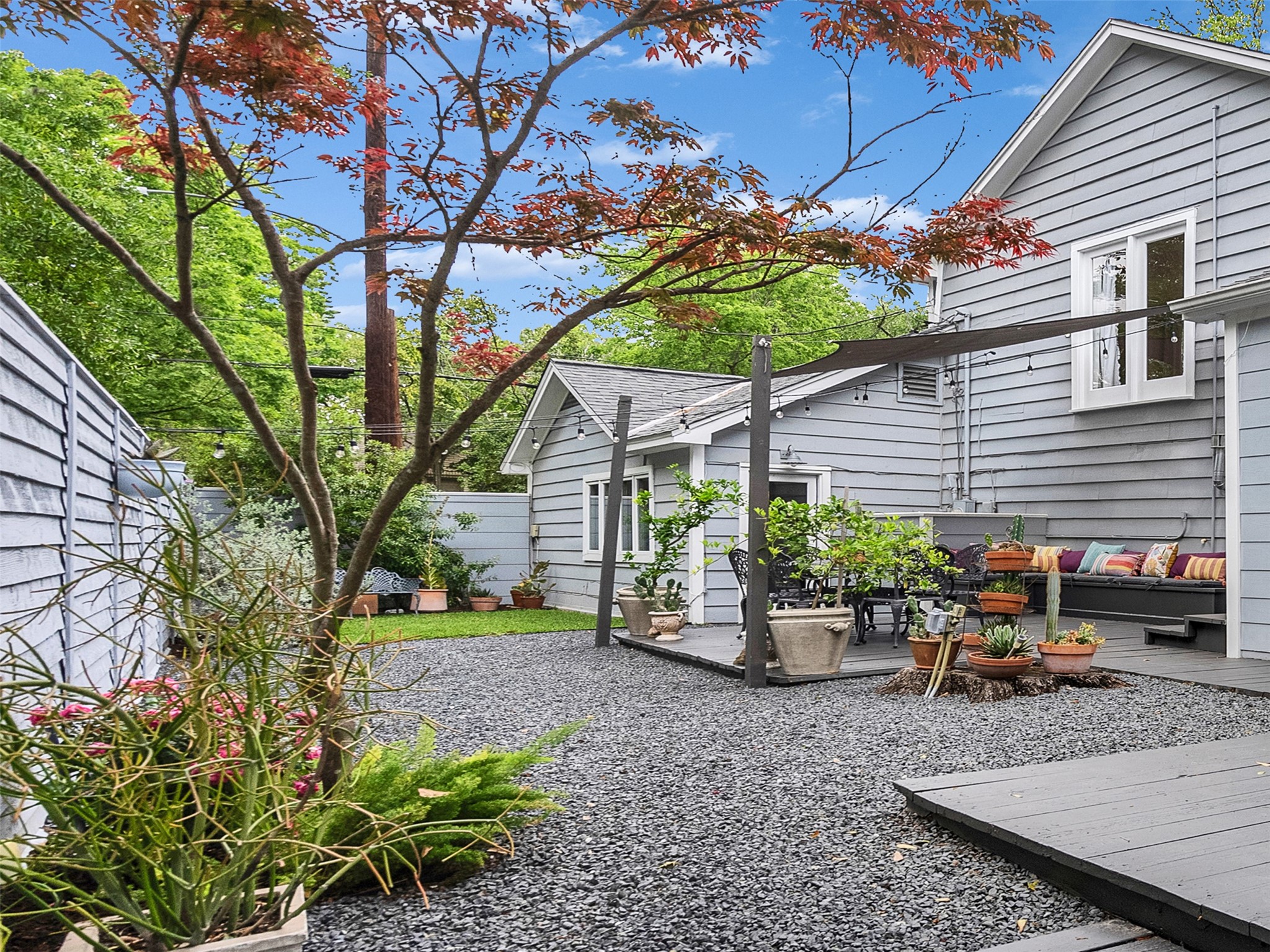 1836 Wroxton Road Houston, TX 77005 - Photo 37 of 42 Lovely backyard with both hardscape for easy maintenance and grassy area as well. A nice dining area draped in twinkle lights opens off breakfast area and back playroom/ flex room and off the screened porch, extending inside-outside living and entertaining.