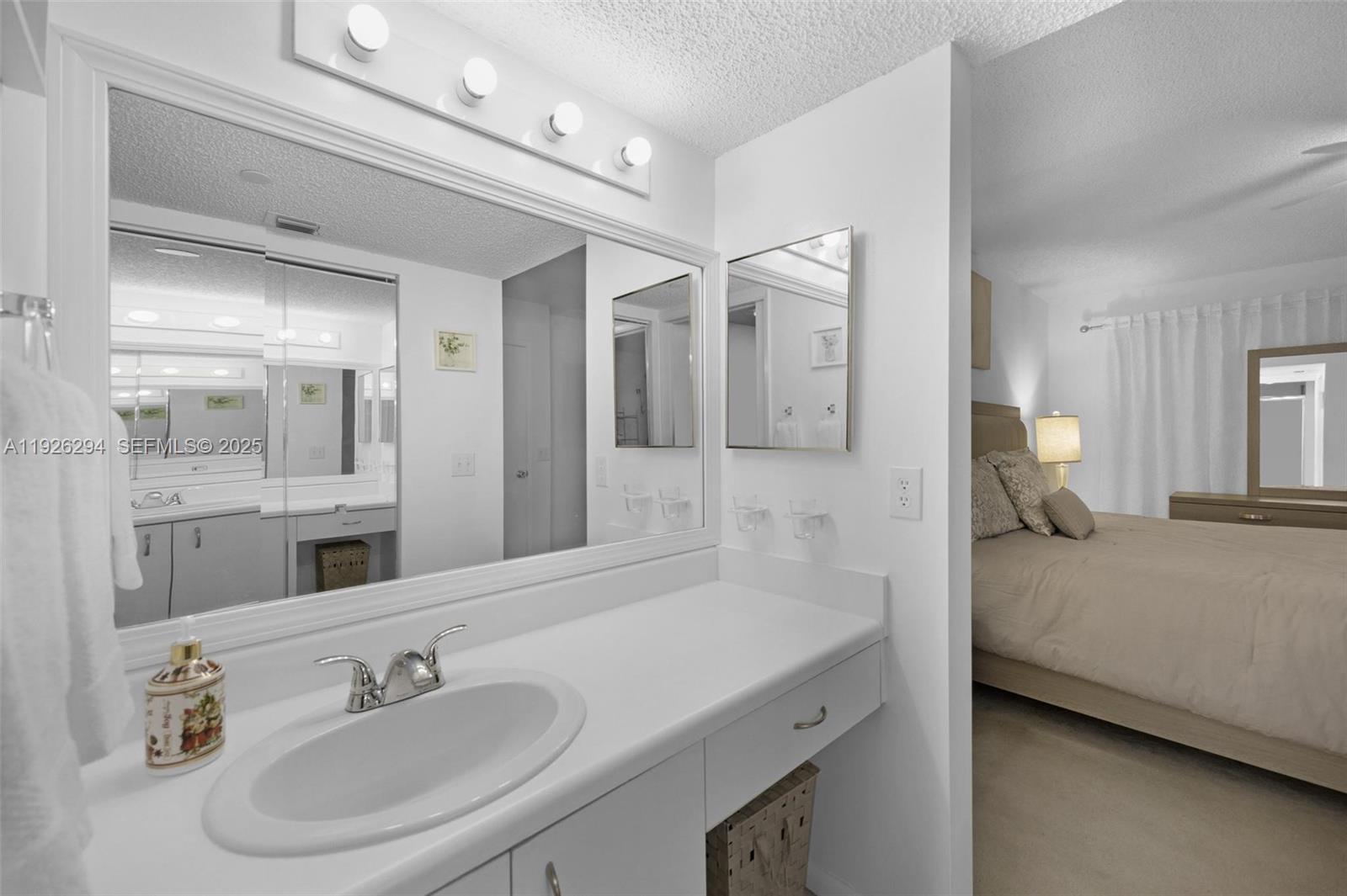 900 Southwest 142nd Avenue, Unit 306L Pembroke Pines, FL 33027 - Photo 11 of 34 a en suite bathroom with a double vanity sink and mirror