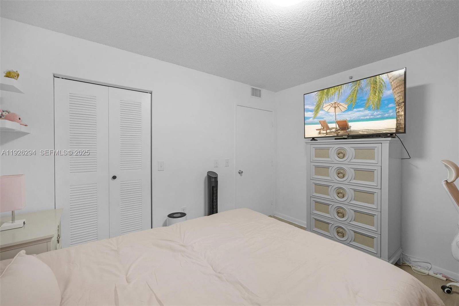 900 Southwest 142nd Avenue, Unit 306L Pembroke Pines, FL 33027 - Photo 15 of 34 a bedroom with a bed and a television