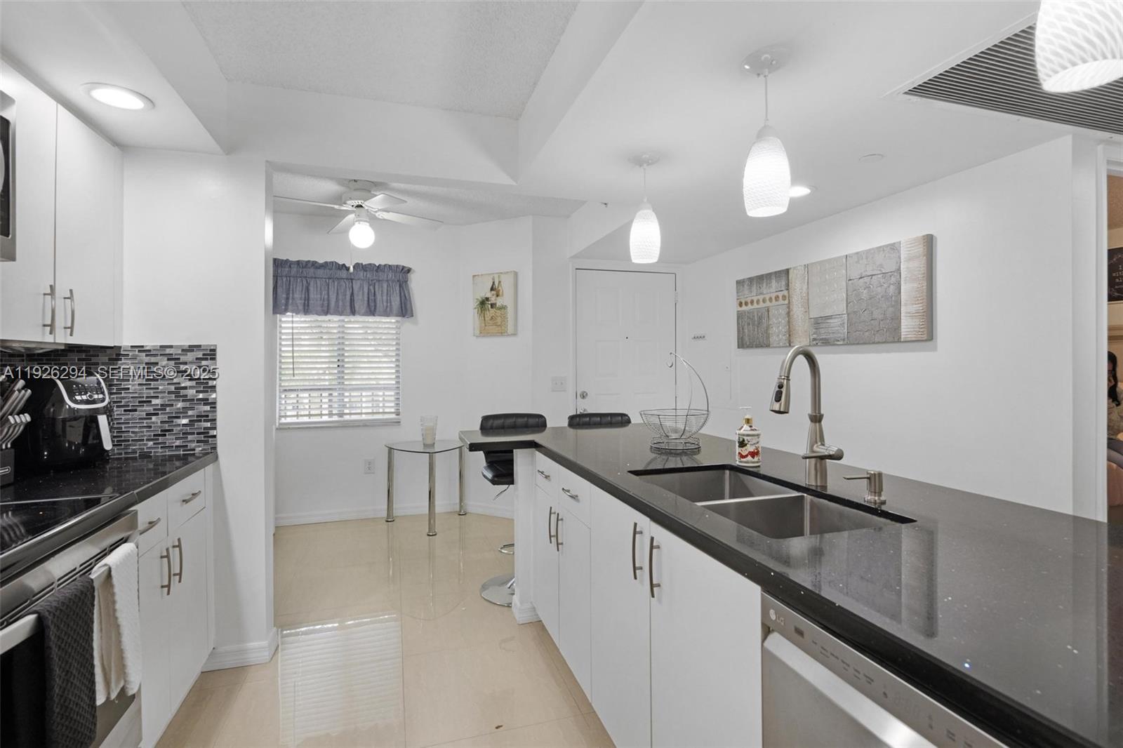 900 Southwest 142nd Avenue, Unit 306L Pembroke Pines, FL 33027 - Photo 22 of 34 a kitchen with granite countertop a sink and cabinets