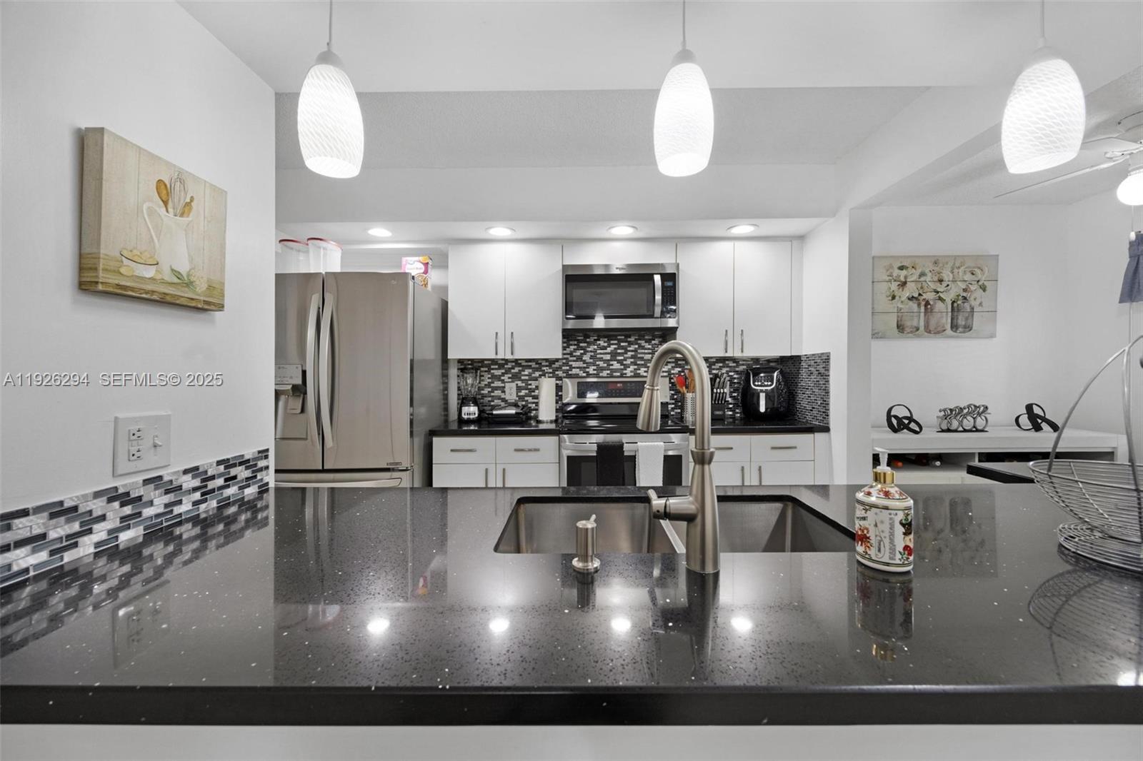 900 Southwest 142nd Avenue, Unit 306L Pembroke Pines, FL 33027 - Photo 26 of 34 a kitchen with stainless steel appliances kitchen island granite countertop a refrigerator and a stove top oven