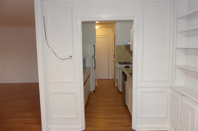 a view of a hallway with wooden floor and staircase