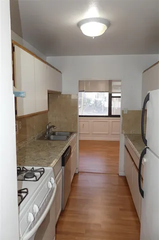 a kitchen with granite countertop a stove and a refrigerator