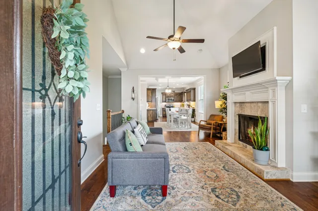a living room with furniture a flat screen tv and a fireplace
