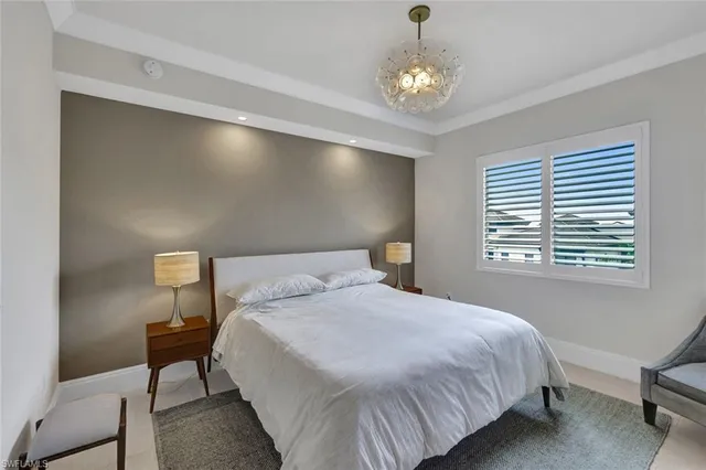 a bedroom with a bed and a chandelier