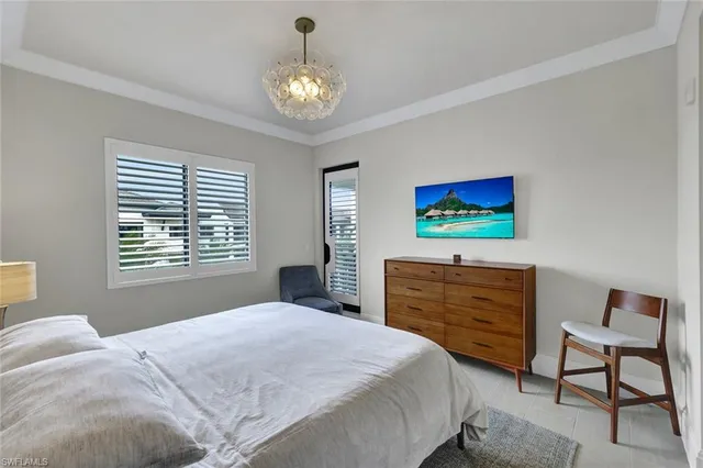 a bedroom with a bed and a chandelier